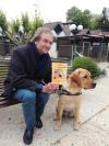 Didier Van Cauwelaert pose avec un chien guide