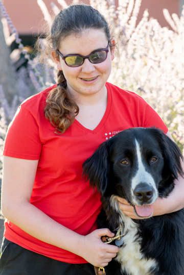 Romane, jeune adolescente ayant un handicap visuel pose avec Nitro, son chien guide d'aveugle