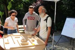 Photo de trois personnes, dont un homme déficient visuel qui participe à un atelier.