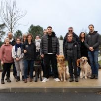 Photo de groupe de salariés de l'association et de Matthieu Jalibert au centre avec à côté de lui un futur chien guide.