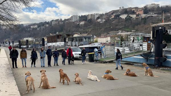 Photo de la 29e promotion de moniteurs de chiens guides durant une séance d'éducation des chiens. À Lyon, sur le bord du Rhône.
