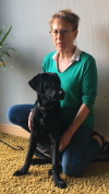 Photo de Claudine, famille d'accueil avec Uben, un labrador noir, un chien guide en éducation.