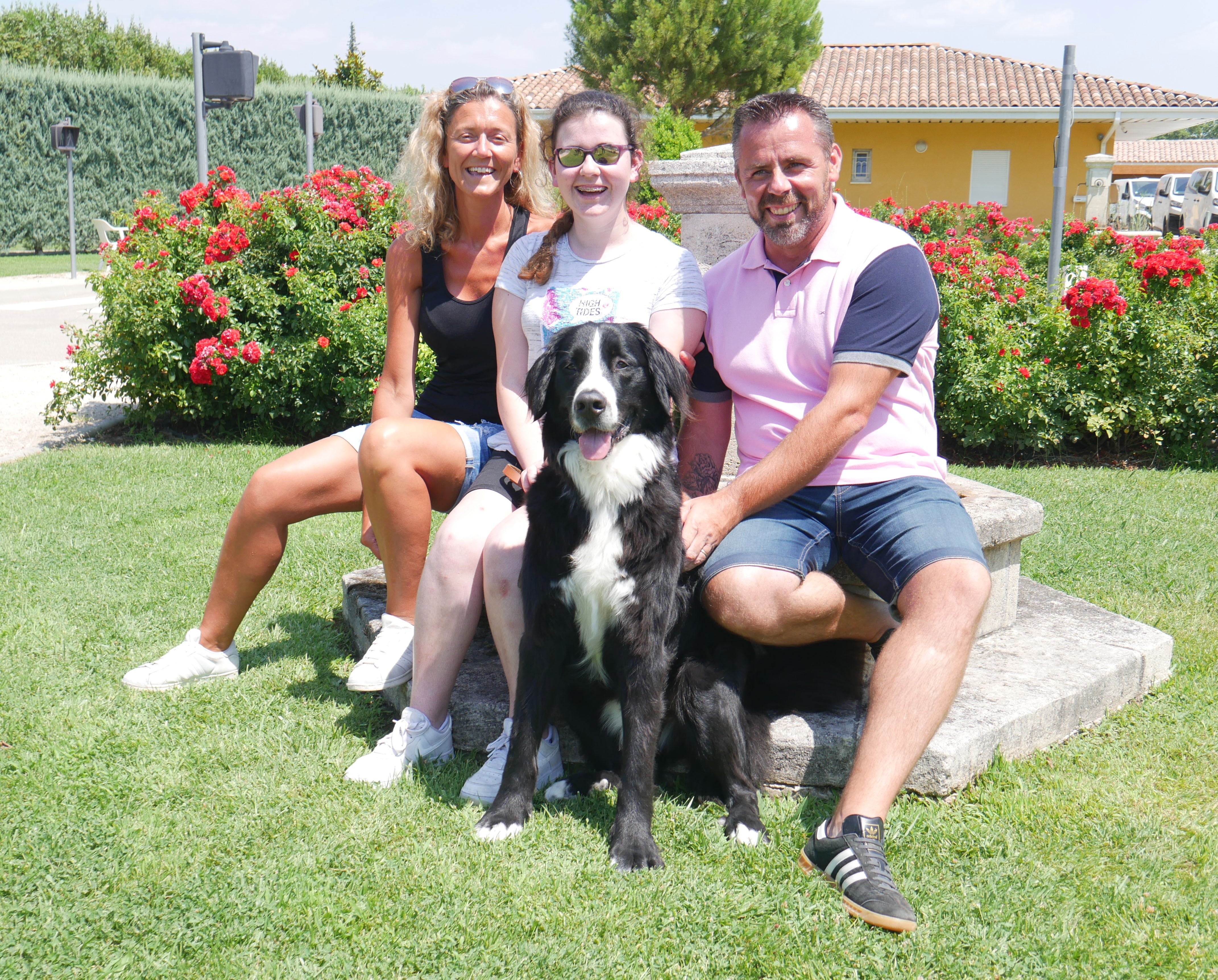 Romane pose avec ses parents et Nitro, son chien guide d'aveugle